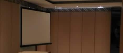 A conference room with a whiteboard, a podium, and a tiled floor.