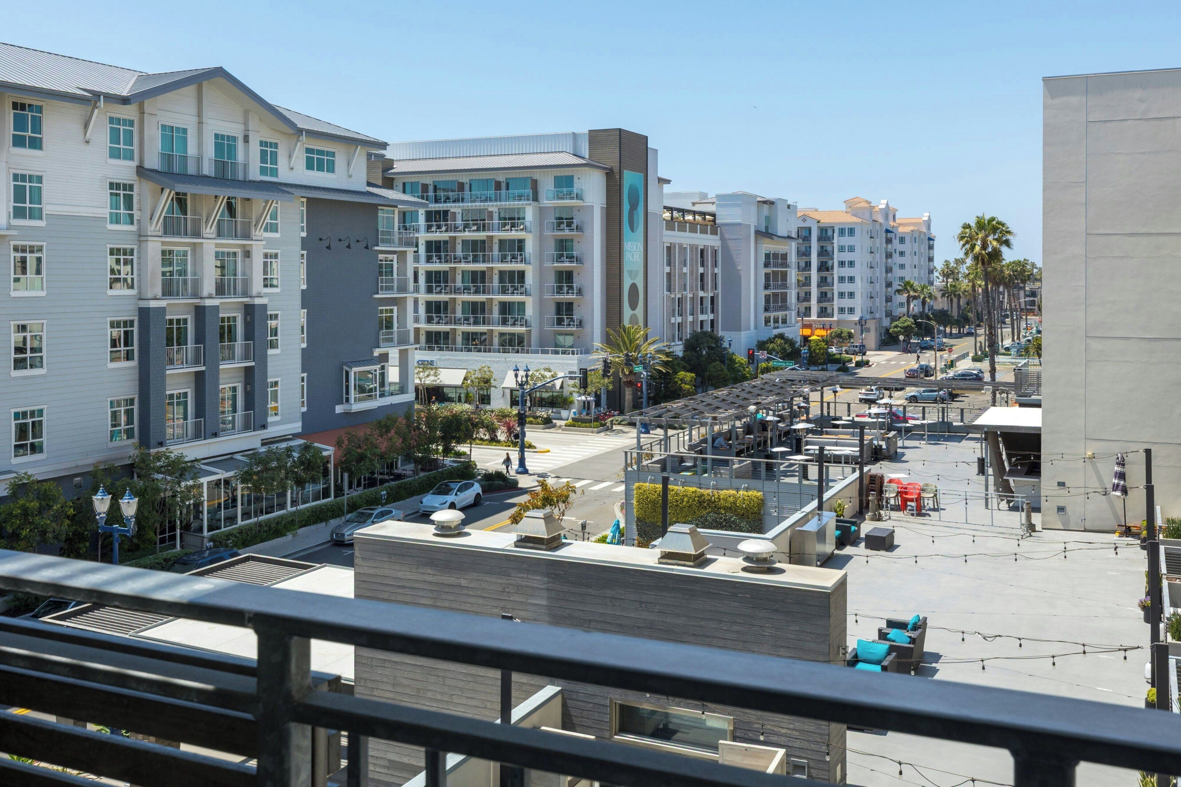Un hôtel moderne à plusieurs étages, doté d’espaces extérieurs aménagés et d’une terrasse sur le toit.