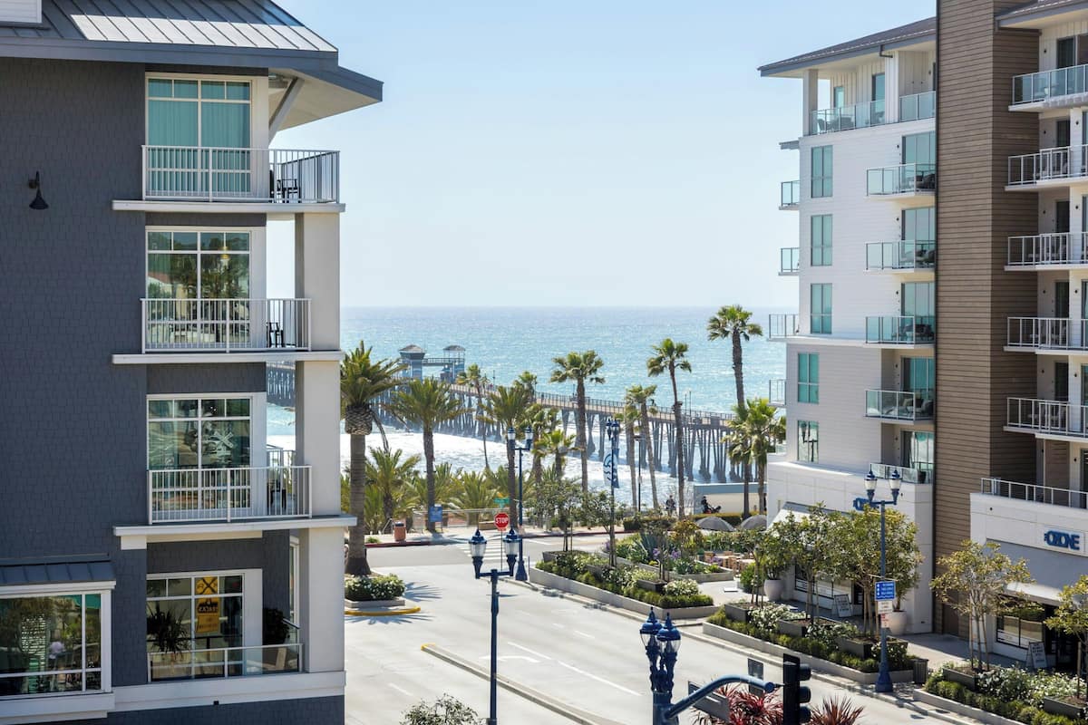 Ein mehrstöckiges Hotel mit Balkonen und Blick auf Strand und Meer.