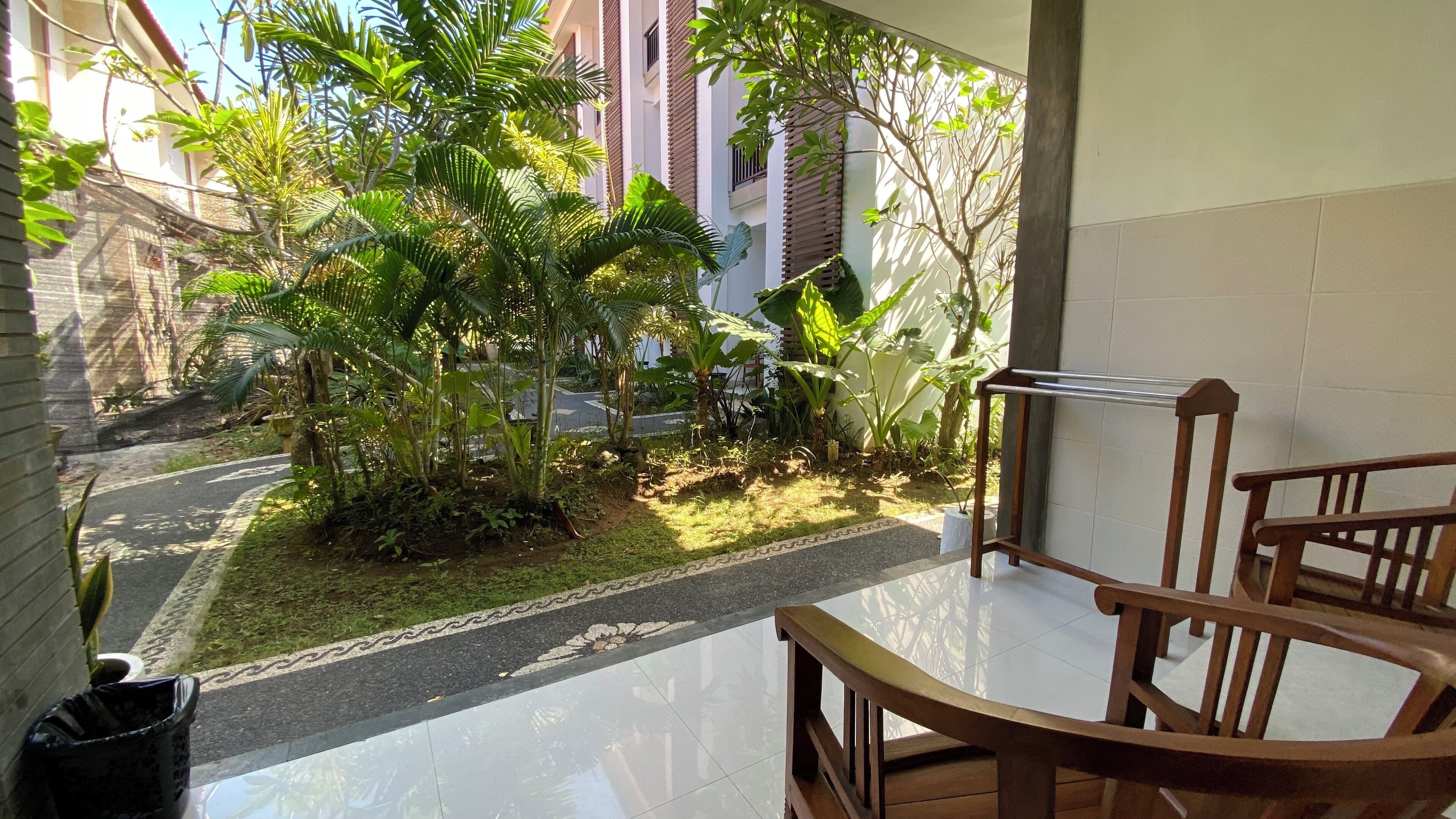 A balcony with a view of a garden and a building.