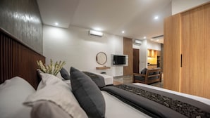 A modern bedroom with a bed, a TV, and a wooden wardrobe. - Sandat Hotel Legian (Kuta)