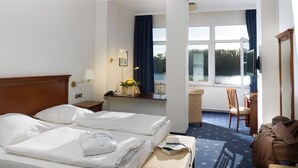 Una habitación de hotel con cama, escritorio, silla y vistas al exterior.