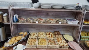 Una vitrina de panadería con diversos productos horneados y cestas de pan.