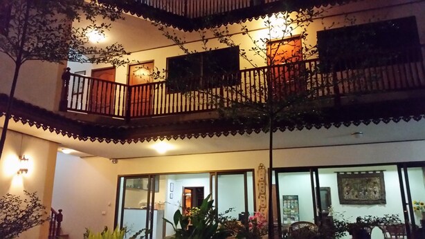 Un edificio de varios pisos con balcones, ventanas amplias y plantas de exterior.