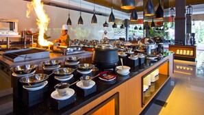 A modern kitchen with a chef performing a flambé. - Hotel Puri Asri (Magelang)