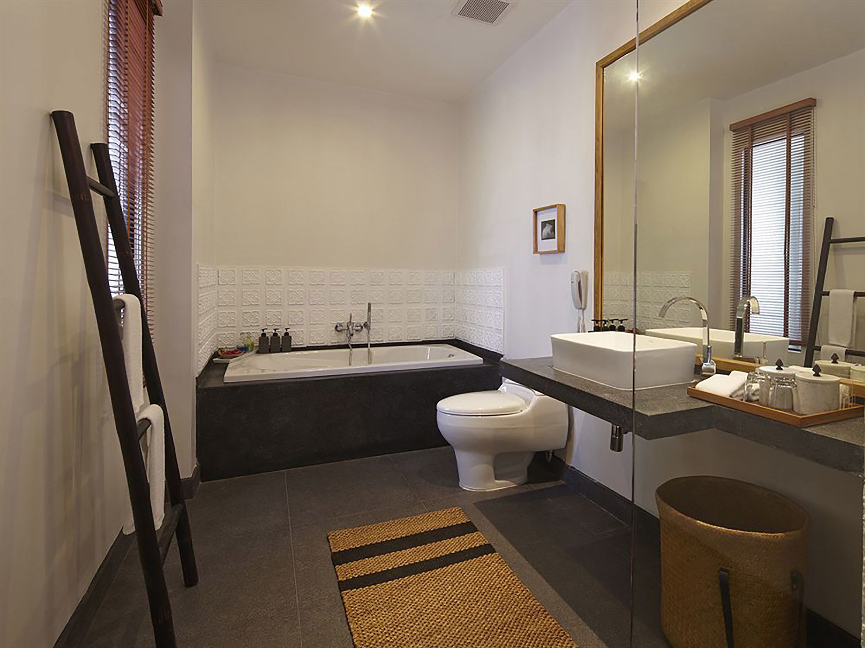 A modern bathroom with a bathtub, toilet, and sink.