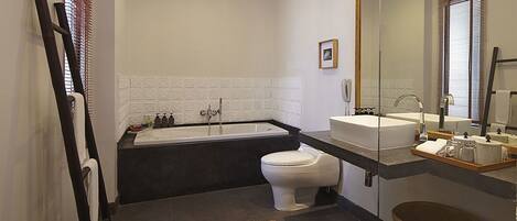 A modern bathroom with a bathtub, toilet, and sink.