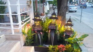 A small outdoor area with a wooden bench, potted plants, and decorative lanterns. - Nantra Huahin (Hua Hin)
