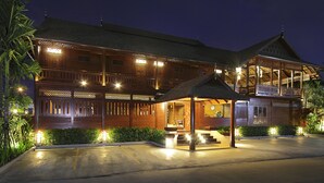 A large, multi-story wooden building with a covered entrance and a balcony.