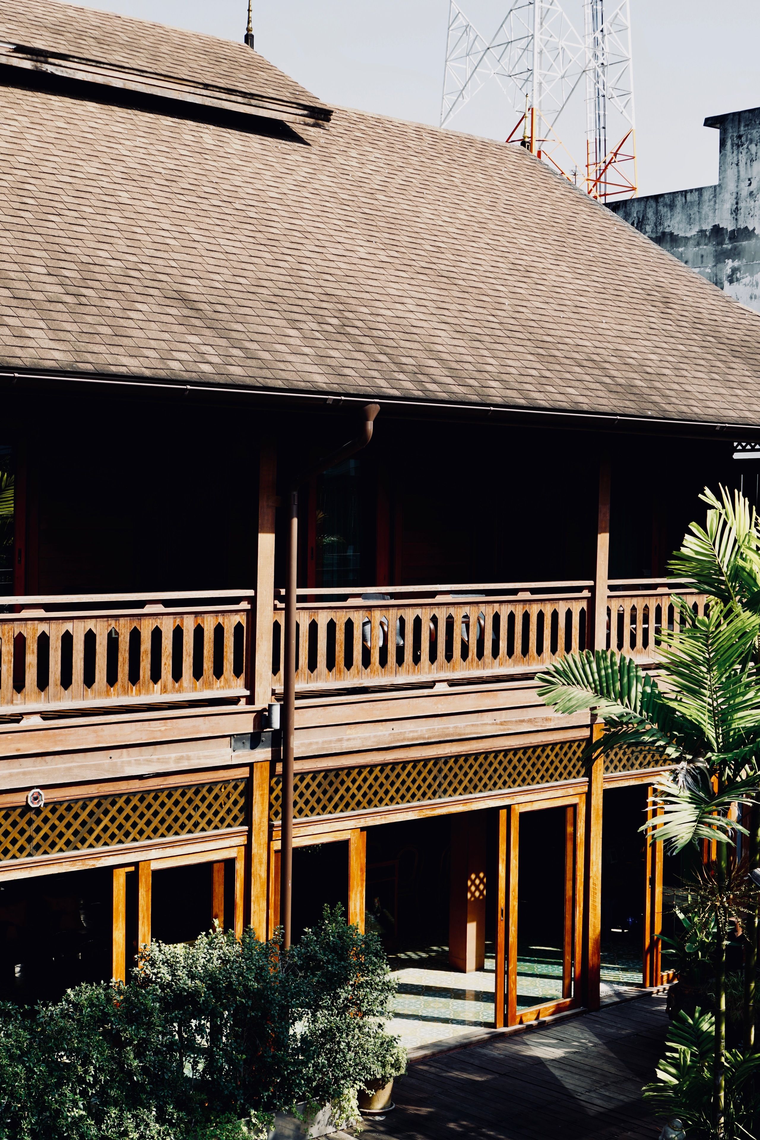 A traditional wooden building with a tiled roof, wooden balconies, and a covered walkway.