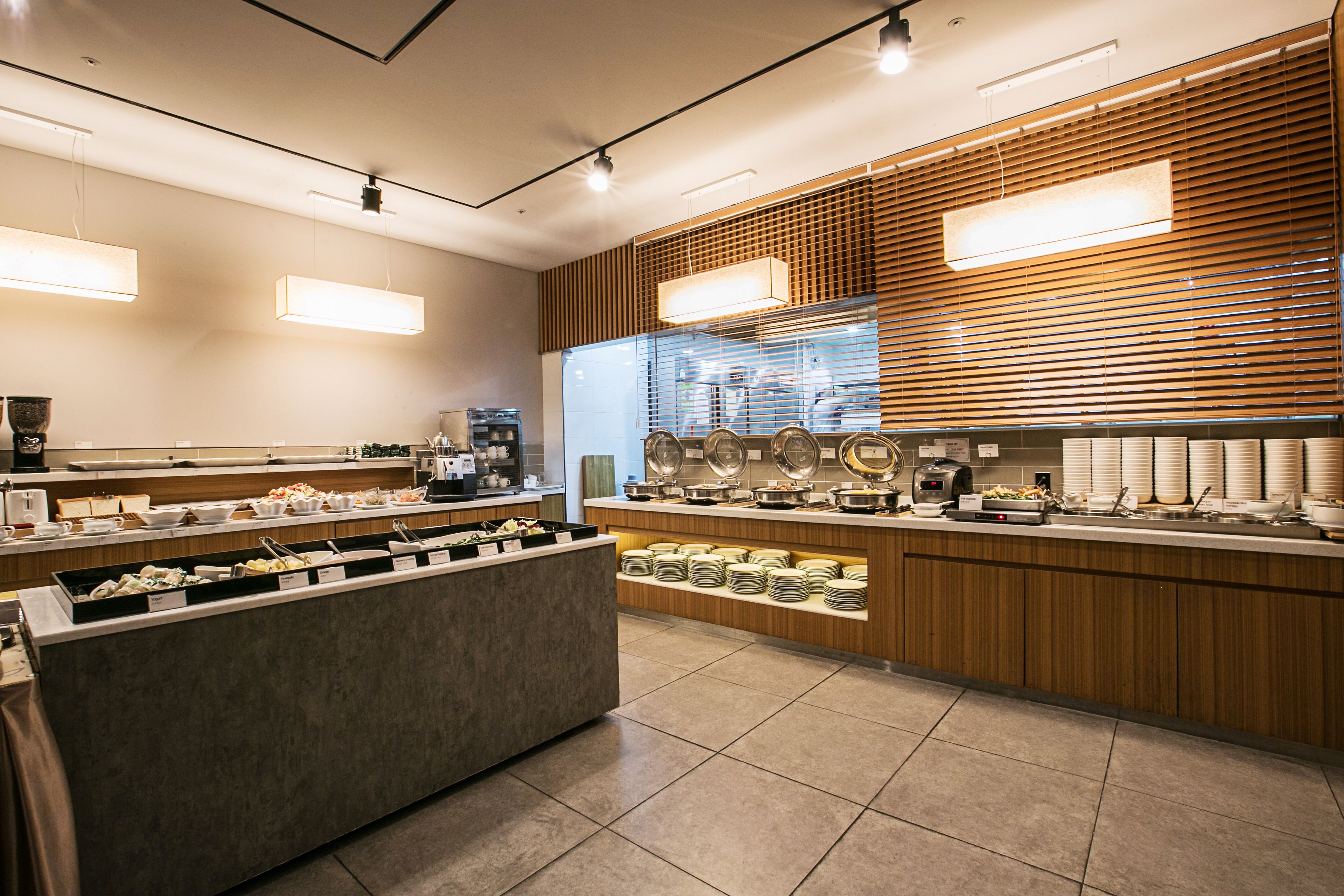 A modern breakfast bar with multiple serving stations, a coffee machine, and a variety of breakfast items.