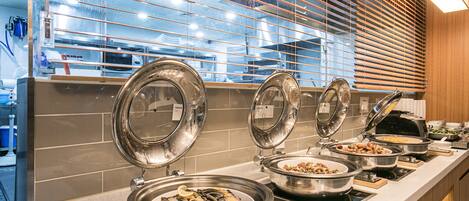 Een buffetopstelling met meerdere food stations, waaronder een zeevruchtenhoek met oesters en diverse andere gerechten.