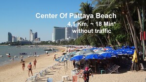 Pattaya Beach with beach umbrellas, lounge chairs, and palm trees. - T5 Suites at Pattaya (Pattaya)