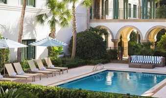 Una piscina al aire libre, sillones reclinables de piscina