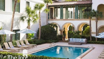 Una piscina al aire libre, sillones reclinables de piscina