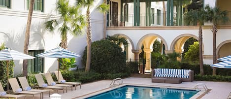 Een buitenzwembad en ligstoelen