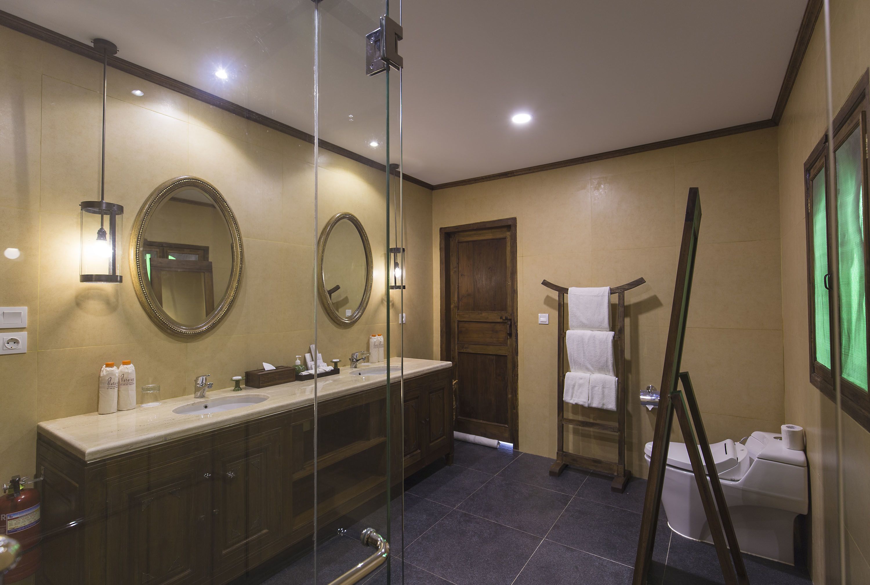 A modern bathroom with a large mirror, a sink, and a toilet.