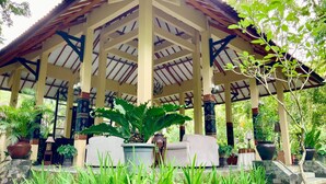 A covered pavilion with a tiled roof, surrounded by potted plants and a stone pathway. - Rumah Boedi Private Residence Villa (Borobudur)
