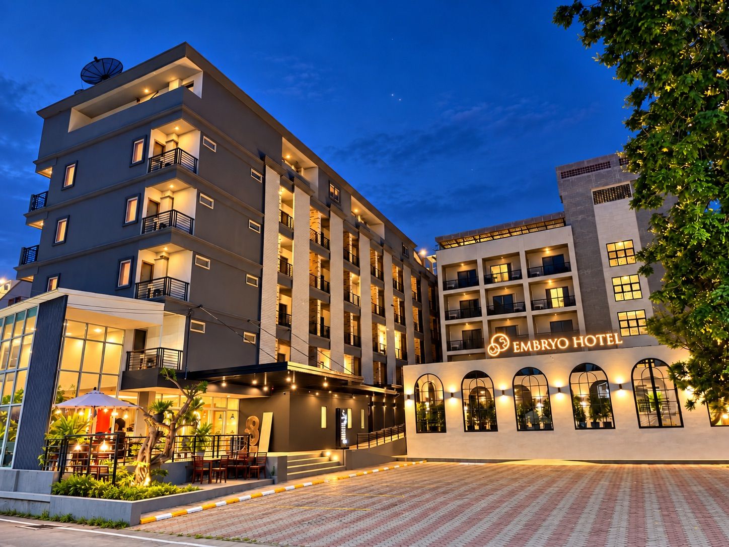 Ein mehrstöckiges Hotel mit modernem Design, mit Balkonen und einem gut beleuchteten Eingang.