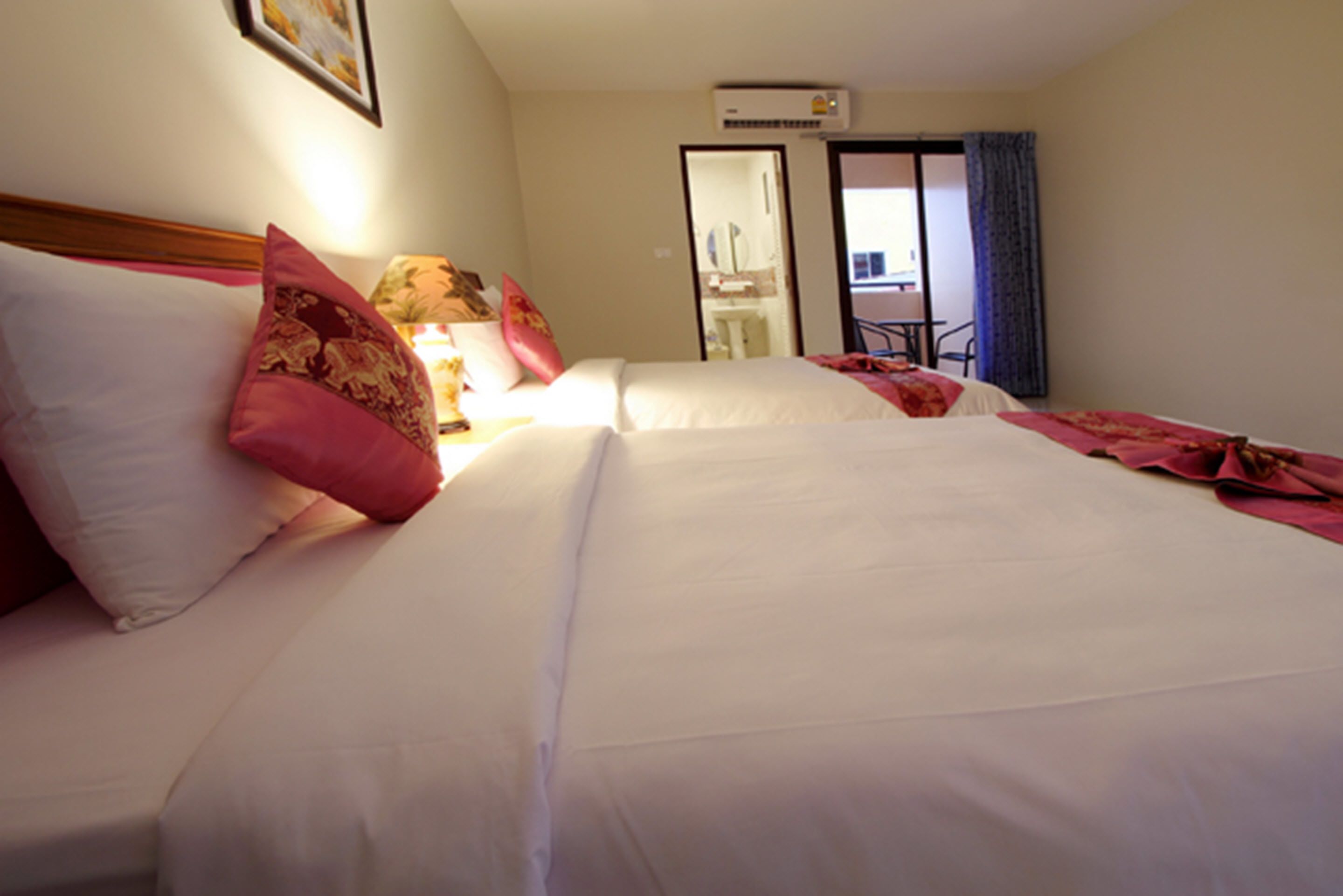 A hotel room with two beds, a desk, and a chair.