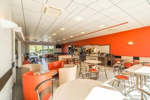 Enjoy meals in a spacious dining area with round tables and individual chairs.