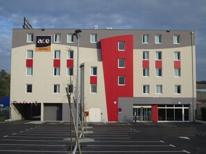 Experience the sleek design of this hotel, featuring a striking red accent and symmetrical windows.