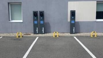 A parking area with marked spaces, including a handicapped parking space, and two electric vehicle charging stations.