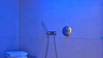 Enjoy a refreshing shower in this stylish space with a wall-mounted showerhead and convenient towel storage.