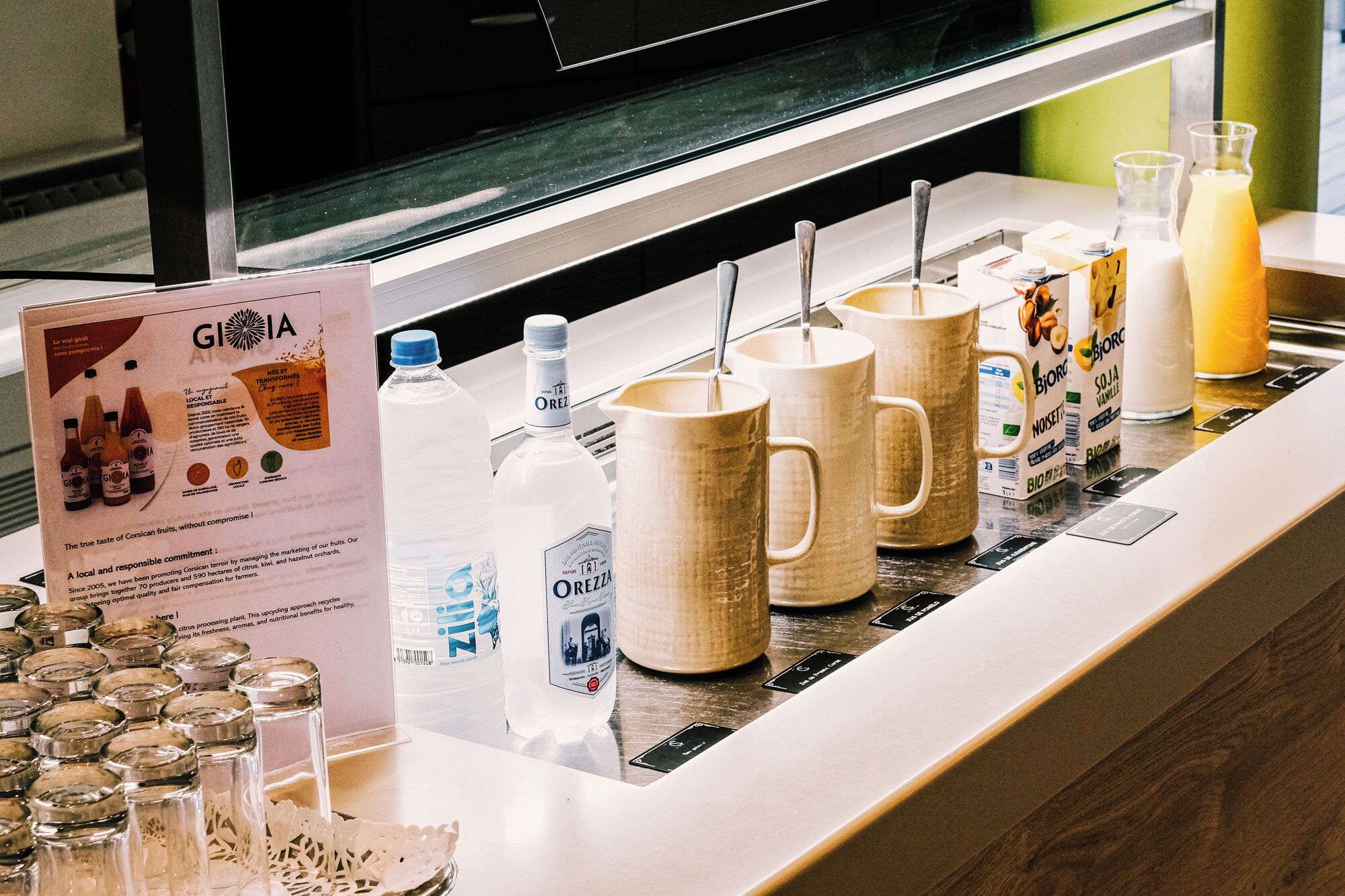 Un espace dédié aux boissons, avec un assortiment de breuvages et un panneau d’information sur GIOIA.