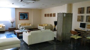 A modern living room with a sofa set, a coffee table, and a TV. - Hotel Jorge Grand (Grandola)