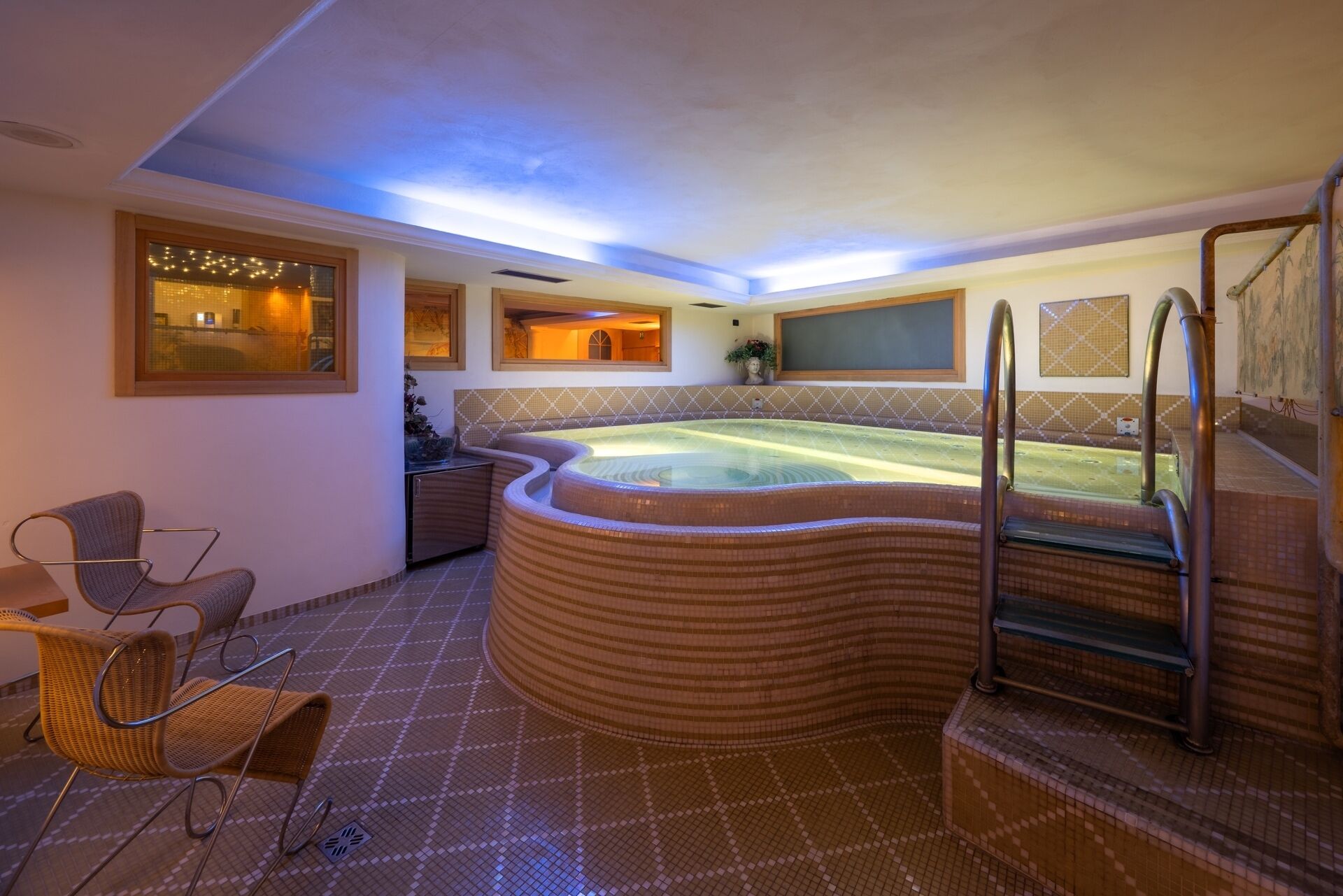 A spa area with a hot tub, seating, and a staircase.