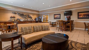 A hotel lobby with a sofa, dining tables, chairs, a coffee station, and artwork on the walls. - Best Western Plus Easton Inn & Suites (Easton)