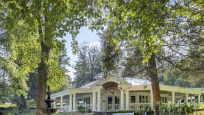 Un espace extérieur abrité comprenant une fontaine, des bancs et un bâtiment orné de colonnes.