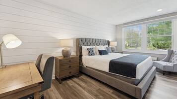 A bedroom with a large bed, a desk, and a chair.