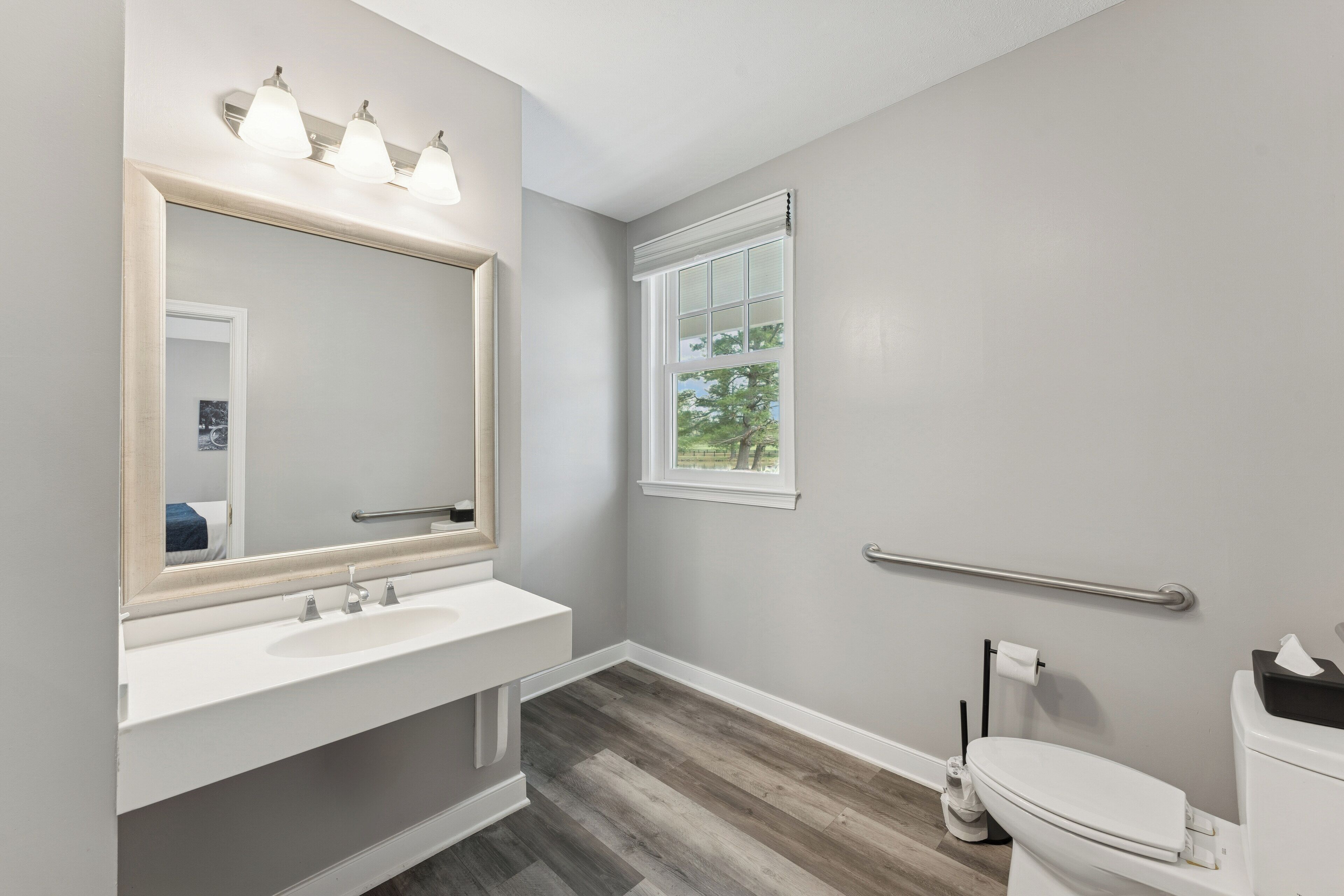 A bathroom with a white sink, mirror, and toilet.