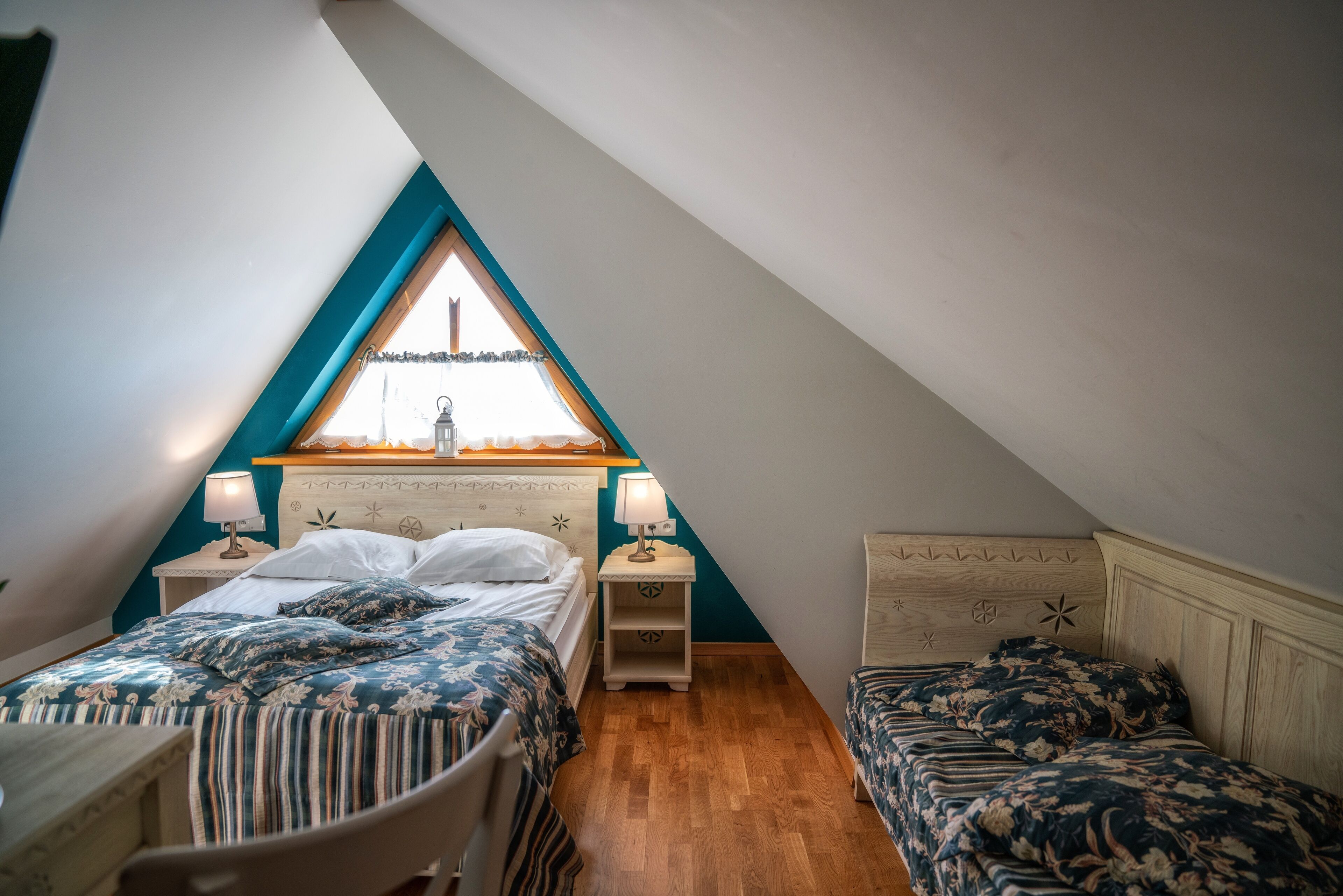 Un dormitorio con dos camas, una ventana con vistas y suelo de madera.