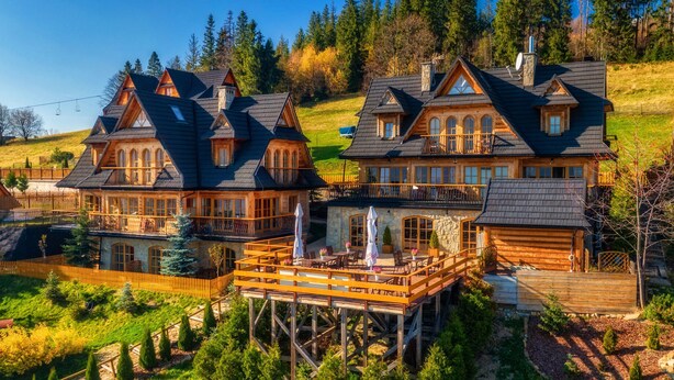 Una casa grande de madera con varios balcones y una terraza de madera.