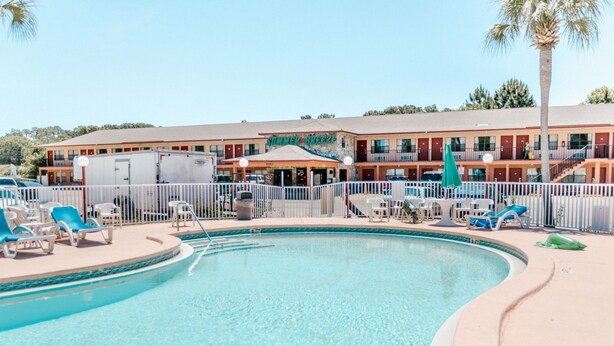 Una piscina con sillones de descanso y un edificio con un letrero que dice 'Numerous Breeze'.