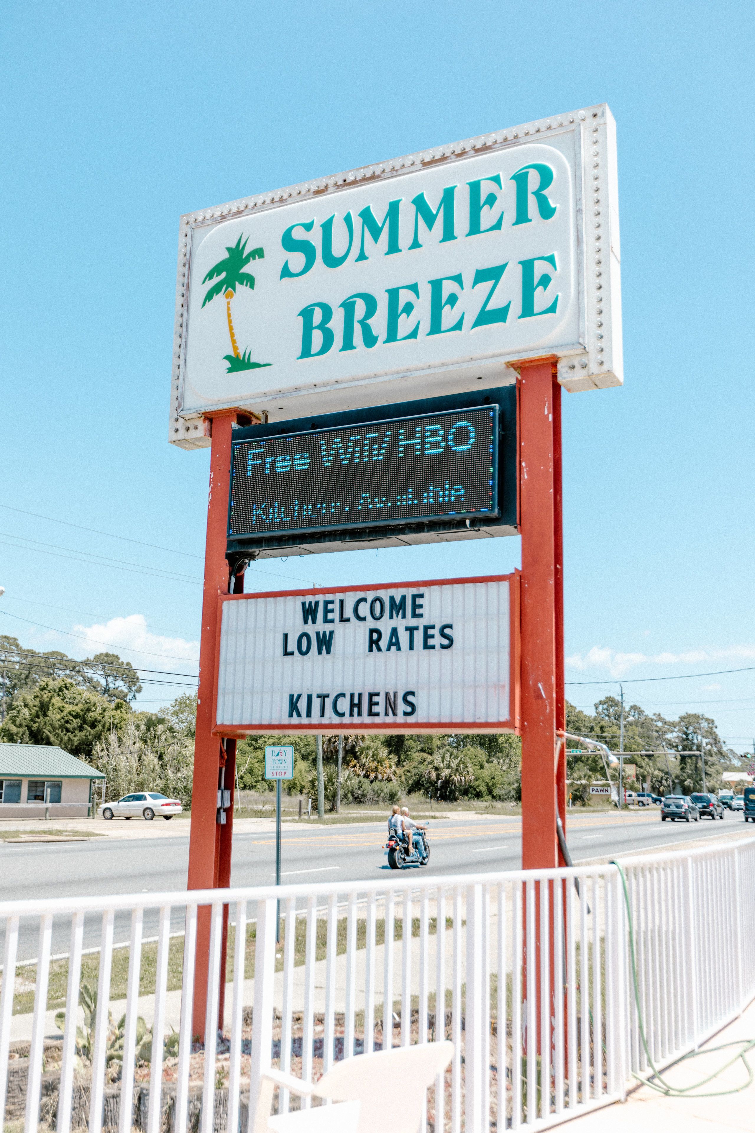 Une enseigne avec les inscriptions « SUMMER BREEZE » et « WELCOME LOW RATES KITCHENS ».