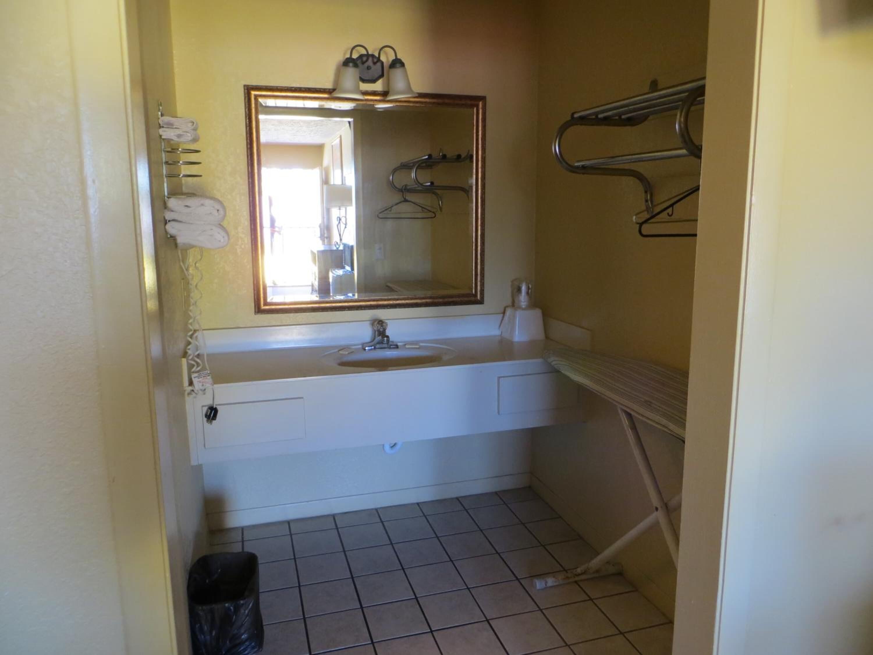 Une petite salle de bain avec un lavabo blanc, un miroir et un porte-serviettes.