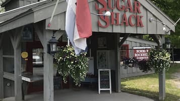 A rustic building labeled "Sugar Shack" with a sign for the Norman Rockwell exhibition.