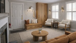 Un salon avec une cheminée, un canapé, une table basse, un meuble et deux fauteuils.