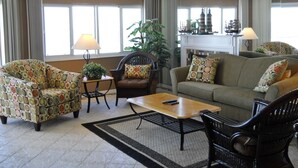 Una sala de estar con un sofá, sillones, una mesa de centro y una chimenea.