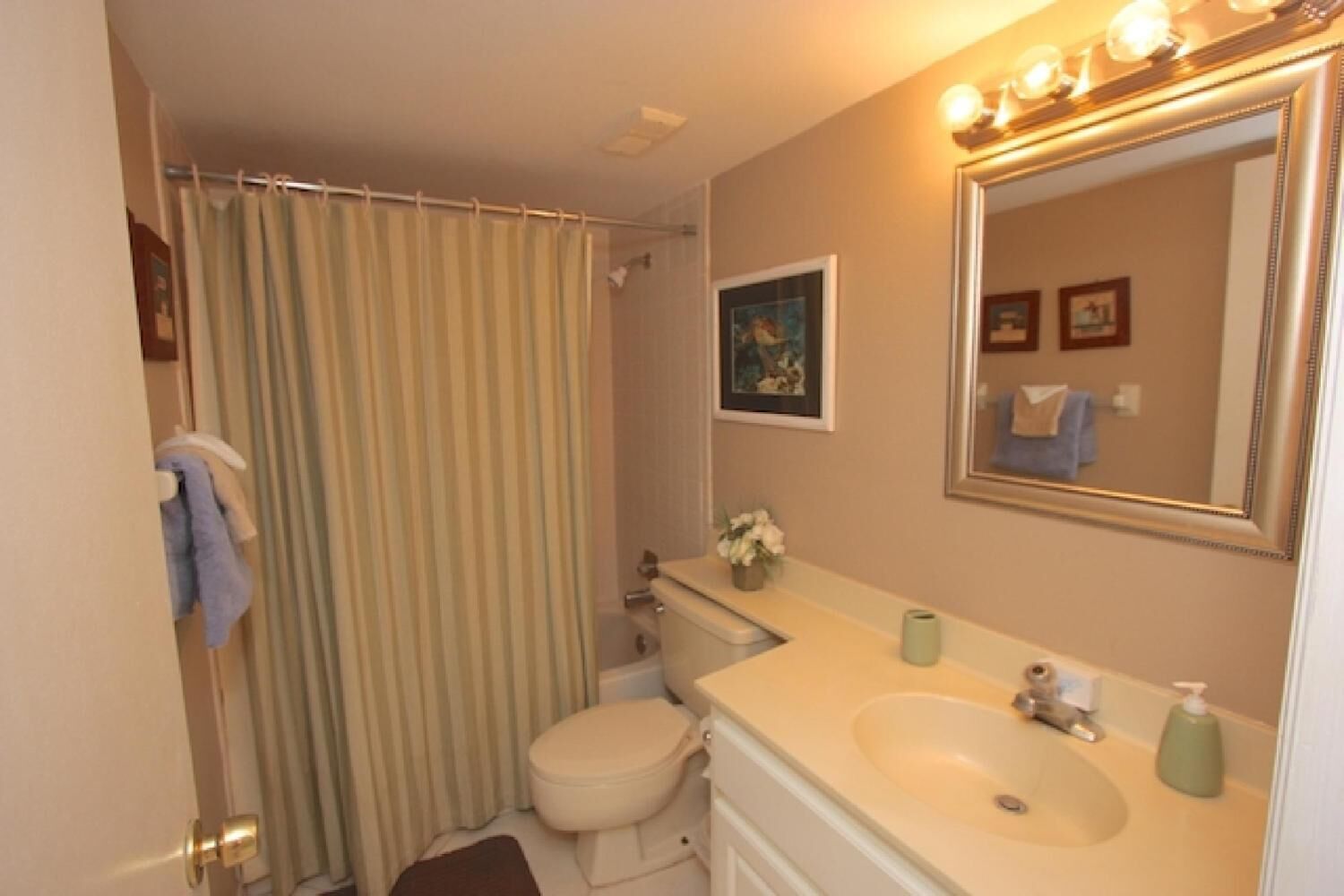 Une salle de bain avec des toilettes, un lavabo et un rideau de douche.