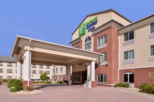 A Holiday Inn Express & Suites hotel with a covered entrance, brick facade, and multiple windows.