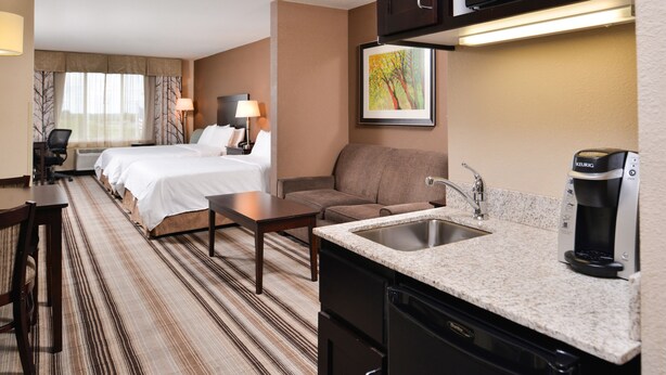 A hotel room with a bed, a sofa, a desk, a coffee maker, and a microwave. - Holiday Inn Express & Suites Emporia Northwest by IHG (Emporia)