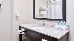 A bathroom with a sink, mirror, towel dispenser, and a hairdryer. - Holiday Inn Express & Suites Emporia Northwest by IHG (Emporia)