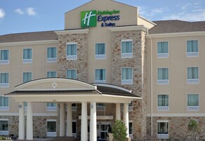 Edificio de Holiday Inn Express & Suites con fachada de piedra, múltiples ventanas y entrada cubierta.