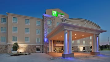 Un hôtel Holiday Inn Express & Suites doté d’une entrée couverte et d’une façade en pierre.
