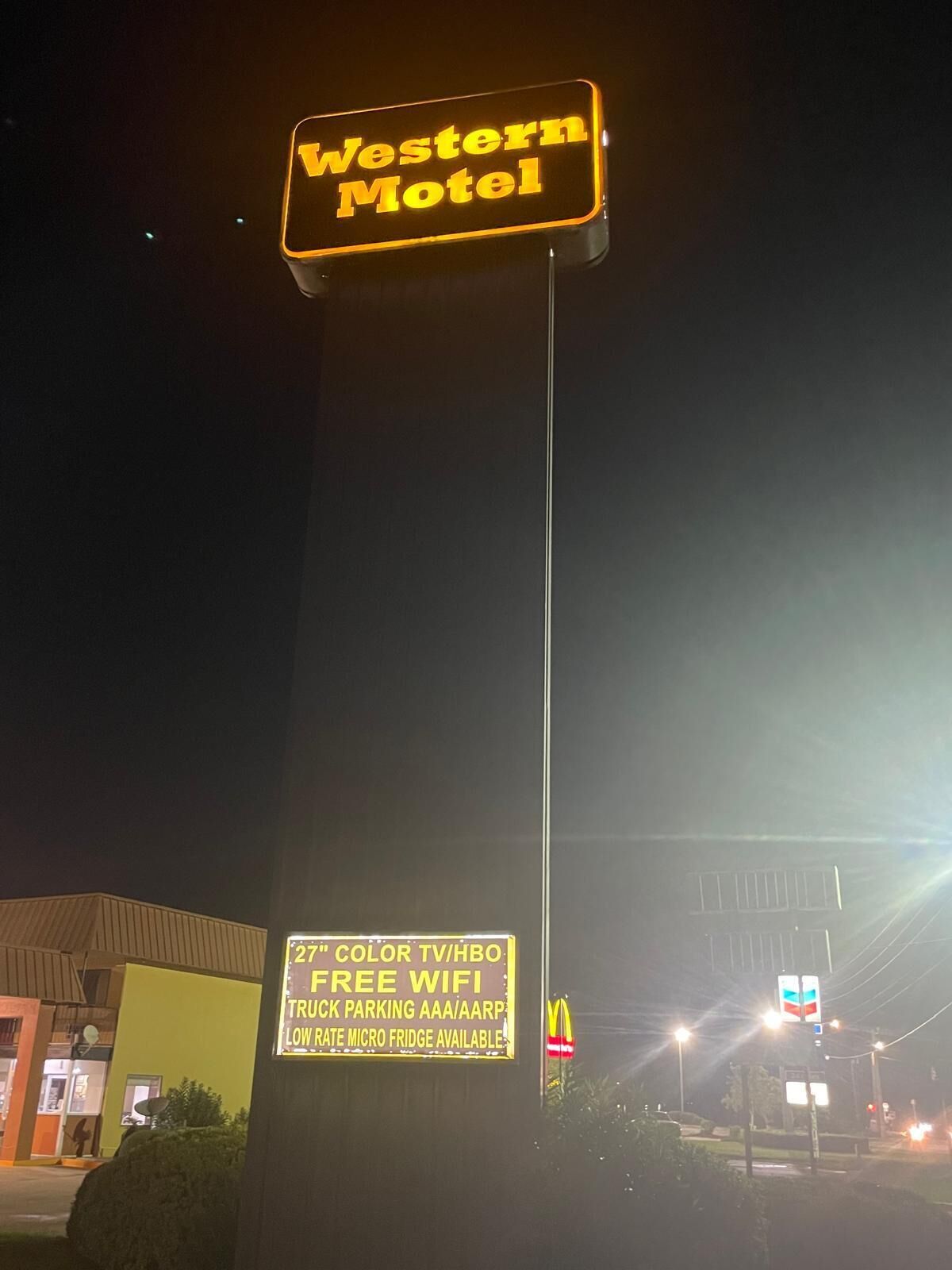 Señal de Western Motel con servicios que incluyen televisión en color, WiFi gratuito, estacionamiento para camiones y un mini refrigerador a bajo costo.